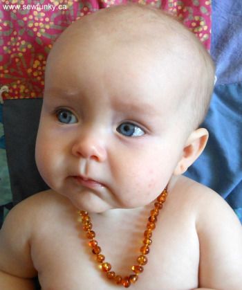 Bebê com colar de âmbar
