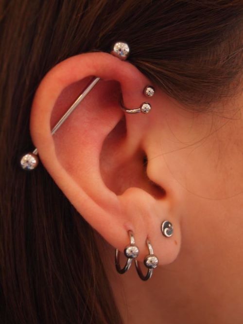 Piercing transversal ou industrial + anti helix complementado por três furos no lóbulo./ Reprodução: Pinterest